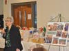 President Paula stands in front of a poster displaying the community work the Lodge is involved with.