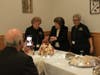 Mary Ann's husband films Carolyn presenting the cookie tree she assembled.