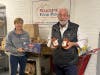 Food pantry volunteers, Rose and Jim, who are also members of the Lodge, accept the pasta and sauce drive donation.