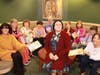 Members offer books to Children's Librarian, Ariel.