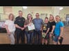 Kim Lambert (third from the left) was surprised by Flint Memorial Library Director Sharon Kelleher, North Reading Police Lieutenant Derek Howe, her husband Caesar and nominator Julian with his parents Julie Elkins and Kristen Morrow.
