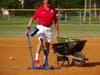 Club Vice President Will Michaels demonstrates pitching machines during batting practice.