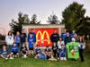 The 11U Rockets team, coaches, and parents take a picture in front of the McDonald's sign before the night of FUNdraising is over.