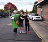 Mrs. Davis dresses as an apple pie while Thomas and Jacob Prescott help sell the pies to customers