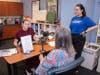 Sofia Roenna (CHS-Downers Grove SLP ’27) evaluates a participant’s vocal volume while physical therapy student Aliyah Crespo (CHS-Downers Grove PT ’27) assists.