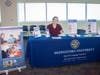 Grace Dolci (CHS-Downers Grove SLP ’27) sits at a table at Midwestern University’s annual Parkinson’s Health Fair. The fair provided education, resources, and support for patients and caregivers living with Parkinson’s disease. 