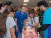 MWU student mentors guide high school students through a simulated intubation exercise.