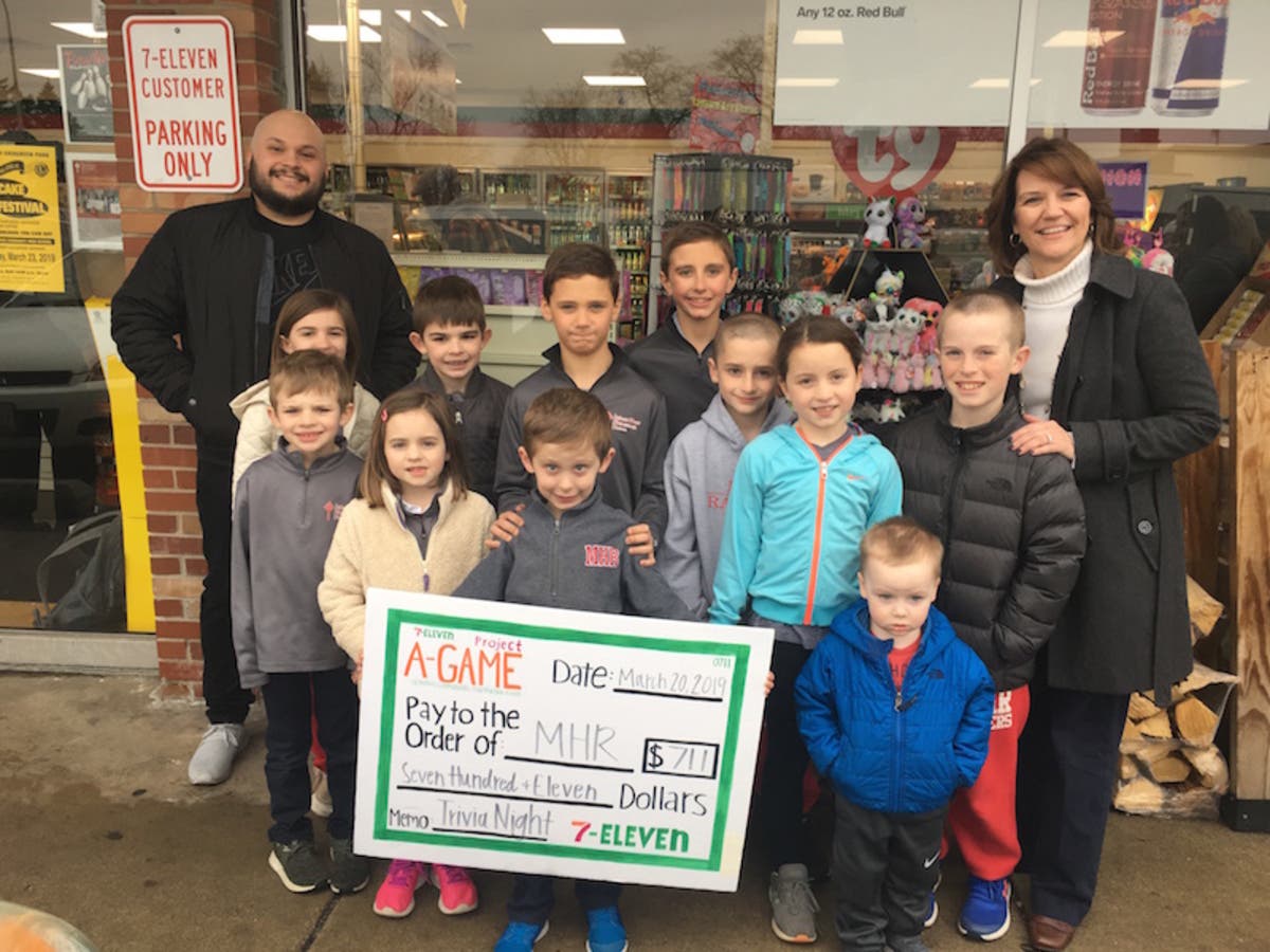 7-Eleven franchisee Hector Murillo, MHR principal Nancy Hamening and students accept a grant from the corporation. 