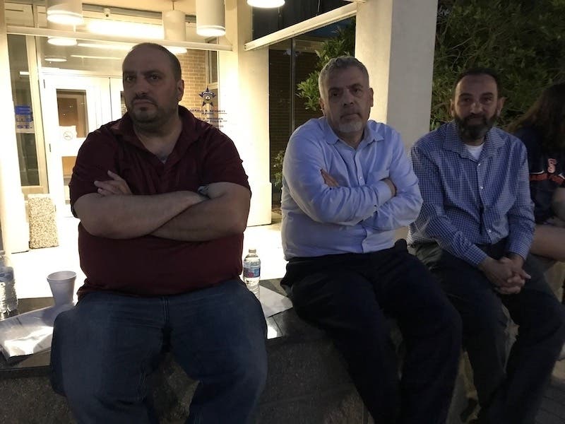 Hatem Abudayyeh (left) sits with two #ResignBrannigan supporters outside the Palos Hills police station.