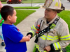 OLFD Fire Chief Mike Mavrogeorge shakes hands with Vinny Ramirez, 5, whose quick thinking may have saved his neighbors' lives and their apartment building from going up in flames.