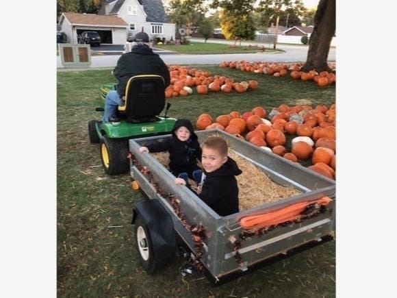 Connell and Brady Quinlan, grandsons of Village Clerk Jane Quinlan, catch a tractor ride at the First United Methodist Church Pumpkin Patch. | Grandma