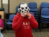 A child tries on a mask from the Boos for Boo Halloween costume giveaway at Chicago Heights Public Library. 