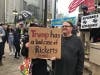 A demonstrator holds up a sign protesting the Ricketts family who own the Chicago Cubs and sponsored Donald Trump's fundraiser luncheon at Trump Tower. 