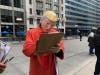 A demonstrator wearing a Trump mask and orange jumpsuit signs a petition to put Democratic delegates on the ballot. 