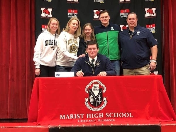 Marist senior Patrick Coogan is surrounded by his family during a signing ceremony on Dec. 16. 