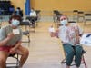 Students flash their vaccination cards during a pop-up COVID-19 vaccine clinic at Stagg High School in Palos Hills. 