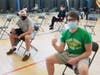 Students flash their vaccination cards during a pop-up COVID-19 vaccine clinic at Stagg High School in Palos Hills. 