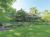 The BAPA Garden Walk on July 11 features an ivy-colored stone house with garden beds filled with brilliant annuals and perennials.