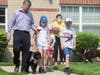 Zoey, a a Portuguese water dog strolls with her family including (l-r) Smith Senior Living CEO Kevin McGee and his children Nora, Grace and Rory in the Smith Village Pet Parade held Friday, July 23 at the Beverly life plan community where pets are welcome