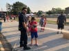 An Alsip firefighter assists a youngster in putting out a cardboard fire. 