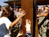 Residents touch the World Trade Center beams after the unveiling of artist Erik Blome's "Heralds of 9/11" sculpture on the tenth anniversary of the 9/11 attacks.