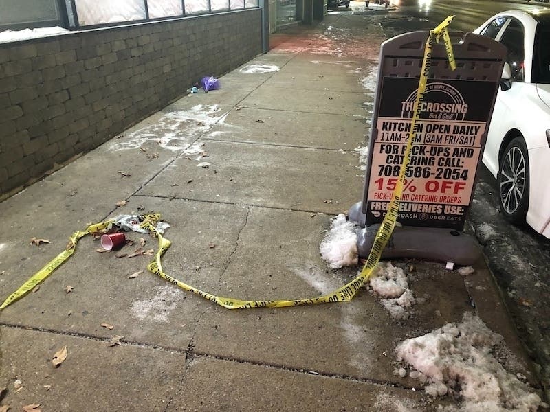 A broken streamer of crime scene tape lays discarded in front of The Crossing Bar and Grill, where two men were shot to death on Jan. 10.