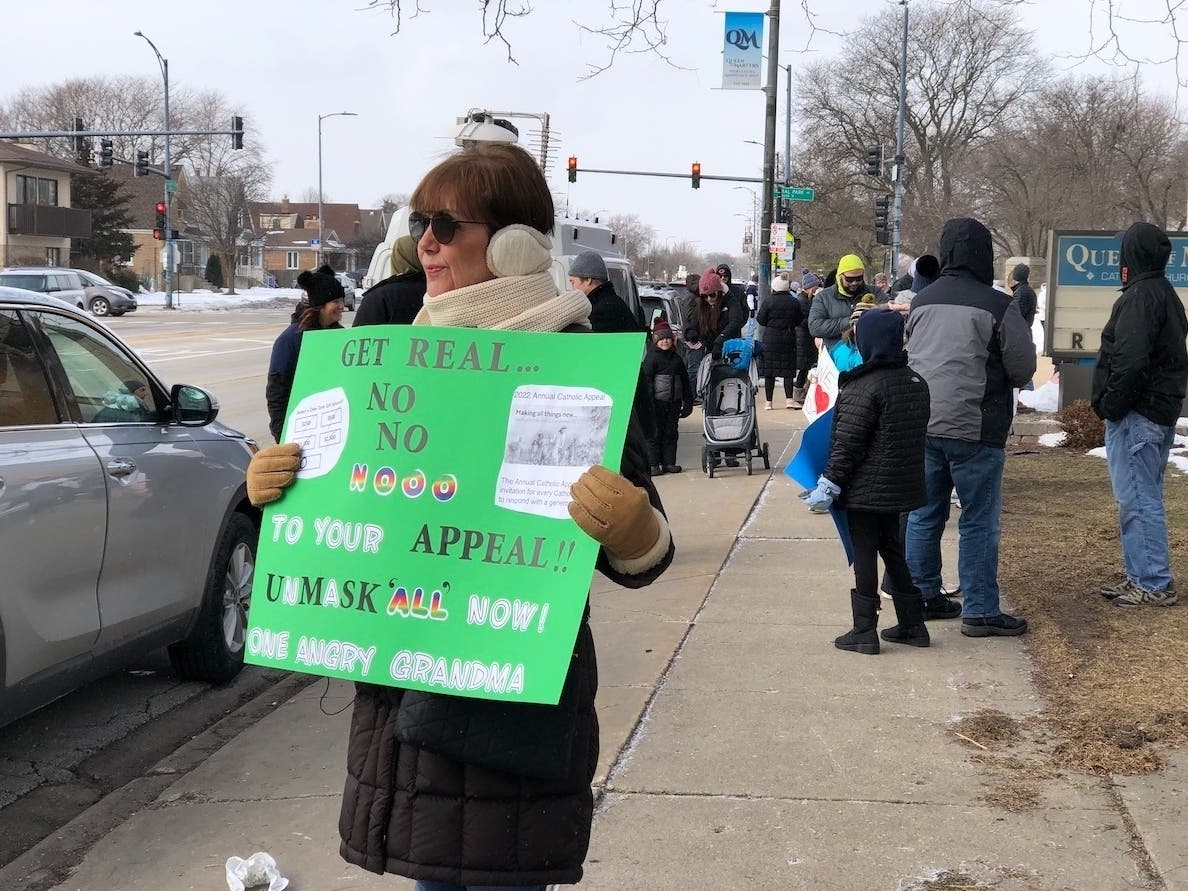A grandmother protests on the steps of Queen of Martyrs calling for reinstatement of principal Doc Mathius who was placed on leave for initiating a mask optional policy without the consent of the archdiocese. 