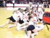 The Mighty Macs celebrate winning the 4A girls volleyball championship against Benet Academy. 