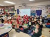 First-graders at Southwest Elementary School hold up wrapped books they received from their EPCHS book buddies. 