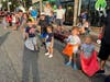 Kids wait at the curb for candy.