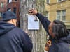 Tio Hardiman, executive director of Violence Interrupters, NFP, and a volunteer hang a flier for missing 13-year-old Dexter Berry on Chicago's South Side. 