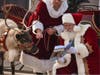 Adam Woodworth, the director of the Children's Museum in Oak Lawn and a professional Santa Claus, reads his new children's book "Twilight: A Reindeer Tale" to Vixen at a reindeer farm. 