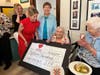 Maureen Gainer Reilly (in red), a board member for Catherine's Caring Cause, presents a symbolic check donated by SPUR to Mercy Sister Pat Murphy (middle) in honor of her 95th birthday. 