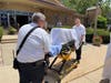Two Evergreen Park paramedics carry the tabernacle to be loaded into an ambulance following the last mass at St. Bernadette Church.