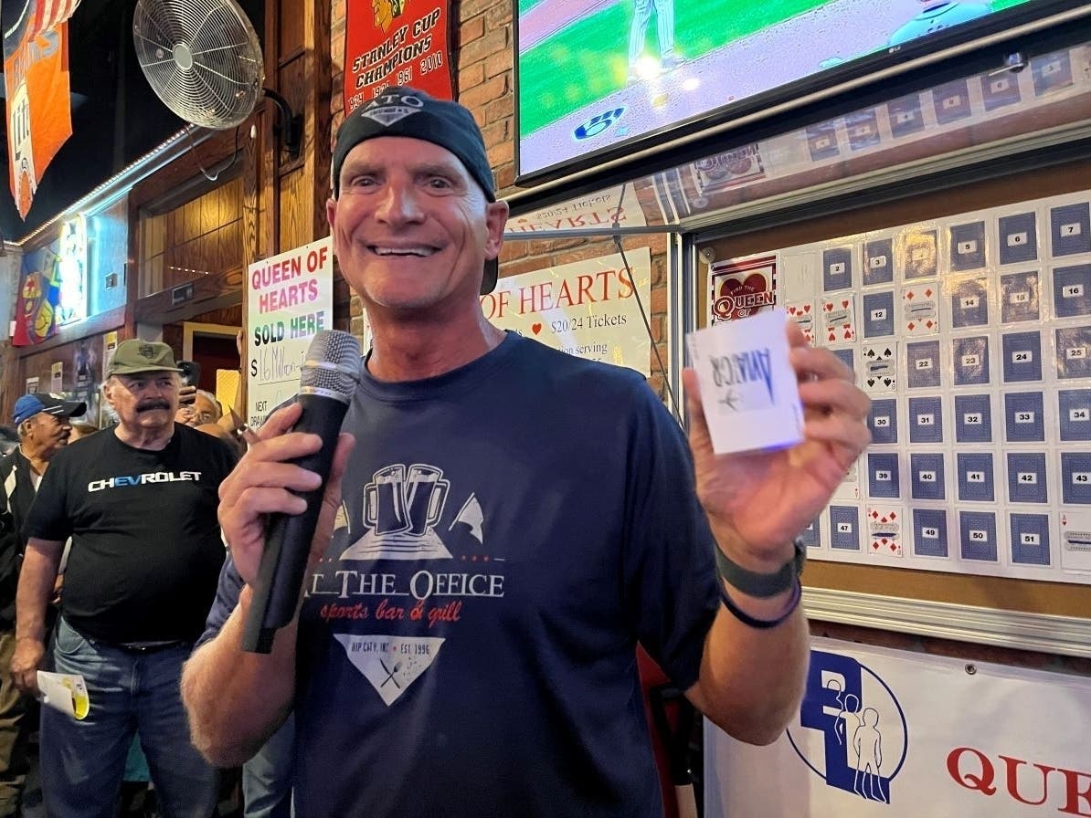 The stylish Tim Newsome, owner of At the Office Sports Bar & Grill, 4901 Cal-Sag Road, Crestwood, holds the joker in the Park Lawn Queen of Hearts drawing.
