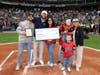 (Left to right) Jack Tinberg and Dan Weishar, of the Andrew Weishar Foundation, Karla Marquez, Eric Marquez, Melanie Marquez and Rose Horcher (AWF) Isaac Marquez (front) present a check for $10,000 to the Marquez family. 
