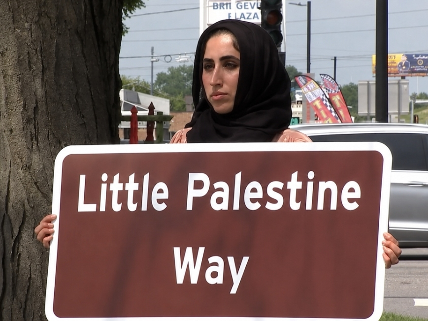 Sabha Abour holds a "Little Palestine Way" sign that IDOT was to have installed on Harlem Avenue in Bridgeview.