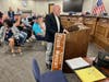 Frank Mancari, holding a replica sign, addresses Oak Lawn Village Board members. 