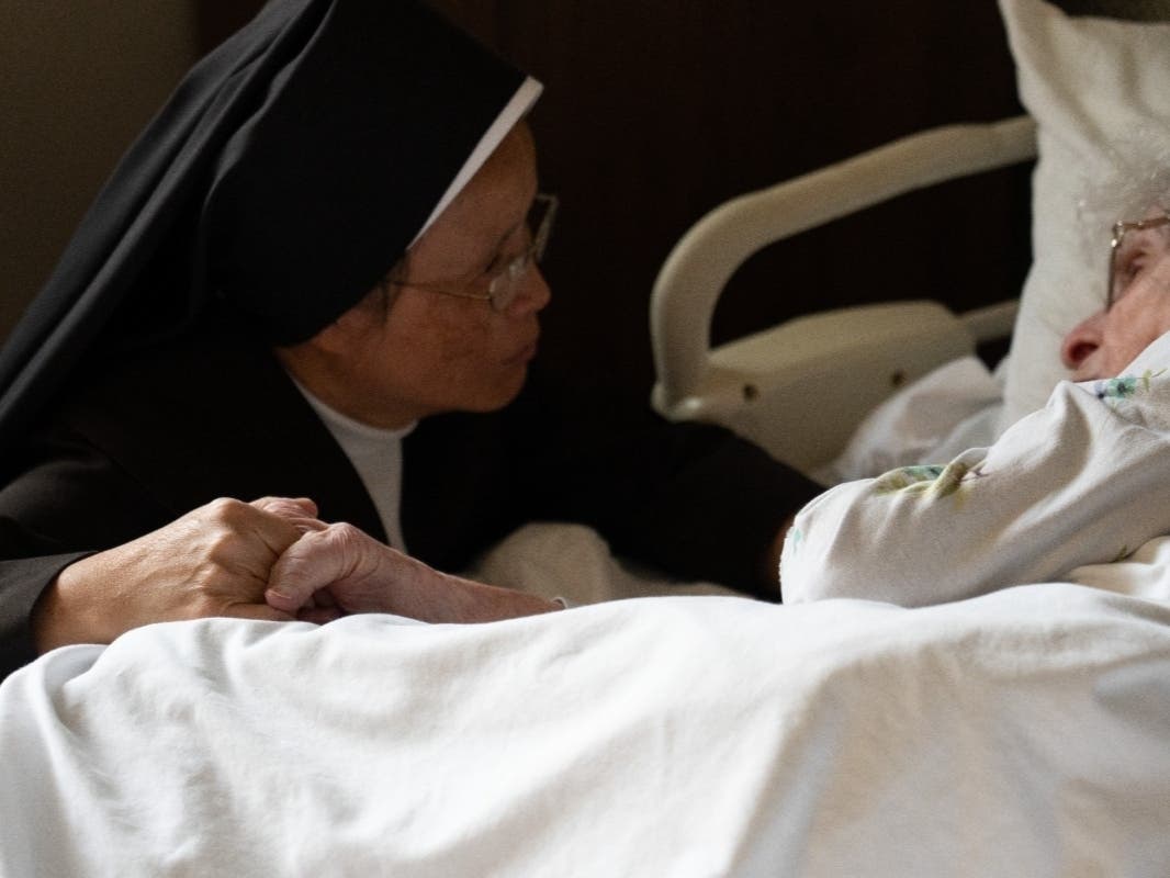 A sister from the Carmelite Sisters for the Aged and Infirm tends to a patient. The Carmelites joined a lawsuit to block Illinois's assisted suicide bill from taking effect on Sept. 12. 