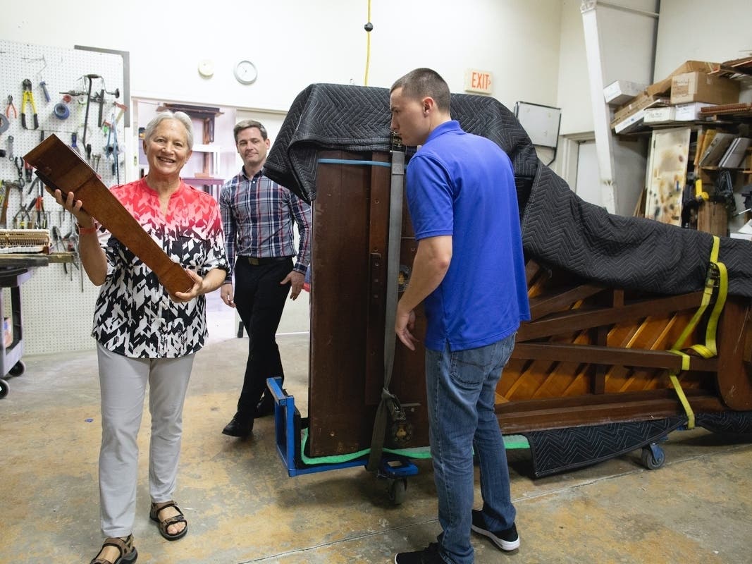 Rebecca Penneys (L), International Steinway Artist and one of the 1973 Steinway donors, helps Music Gallery's technicians get the piano ready for fine tuning