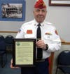 Commandant Neil Clark holds plaque