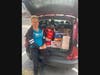 Warminster Food Bank volunteer Renee Hrin Solt picks up some of the food collected by Shir Ami Reform Synagogue of Newtown. The items will be used to make monthly grocery bags for Warminster Food Bank guests.