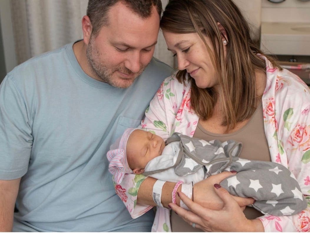 Justeen Moss, her husband and their newborn daughter share a heartwarming moment.