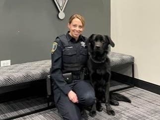 Charlie, a police comfort dog, and his handler officer Meghan Kramer. 