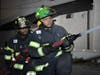 Volunteers Antonio Scott and Jabari Green practice hose work on a drill night. 