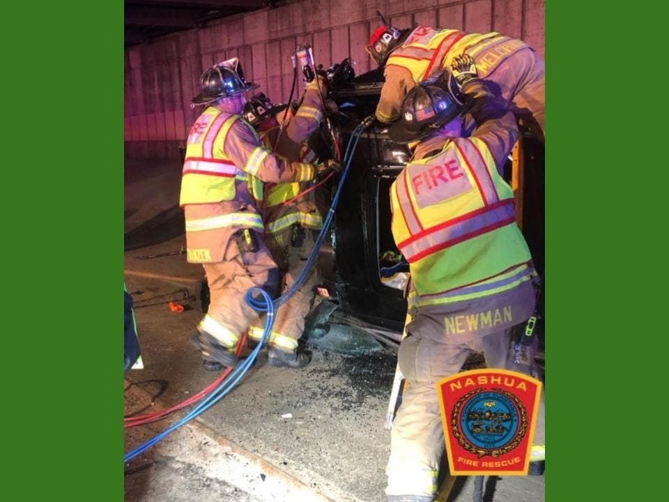 Engine 5 and Ladder 1 firefighters work to remove a driver from a single-vehicle crash on the Everett Turnpike. 