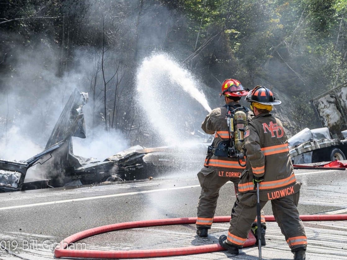 Firefighters work to put out two tractor-trailers burning on I-93 North in New Hampton on July 3, 2019.