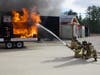 Firefighters extinguish a fire inside of a mock living room that did not have fire sprinklers on Nov. 18.