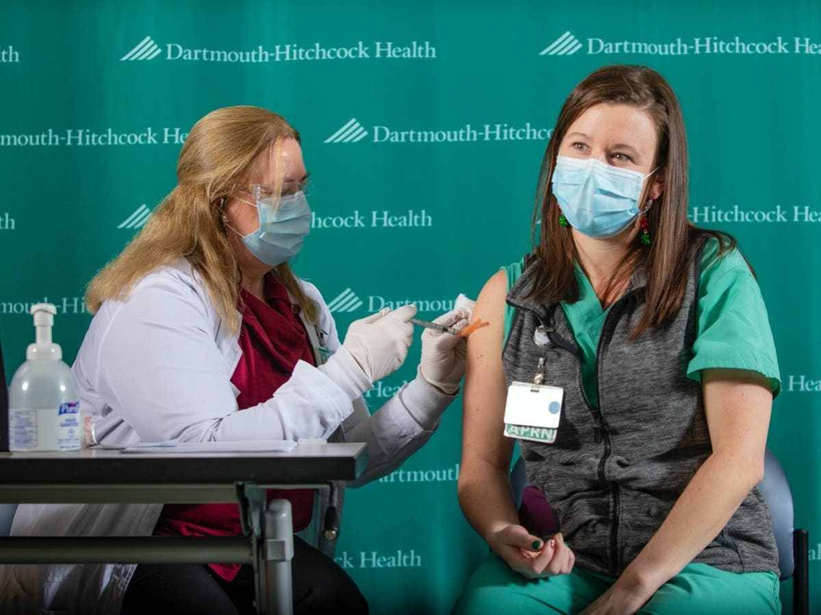 Dartmouth-Hitchcock nurse practitioner Hillary Way, right, received the first COVID-19 vaccination at Dartmouth Hitchcock Medical Center from Occupational Medicine nurse Lisa Brown, left, Dec. 17.