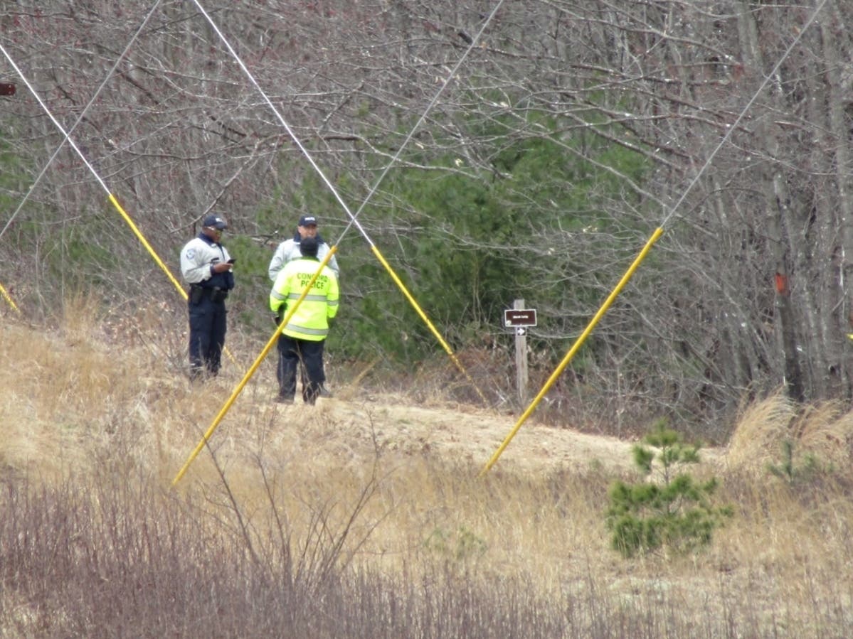 In this file photo from April 22, investigators are seen near the entrance of the Marsh Loop Trail off Portsmouth Street in East Concord.